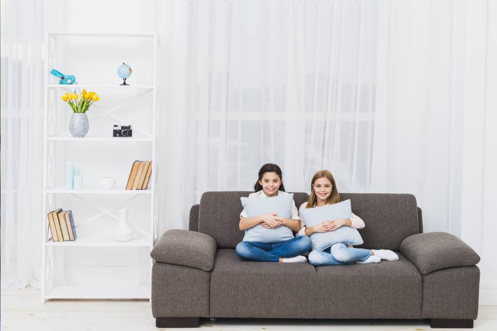 two girls are sitting on the sofa set